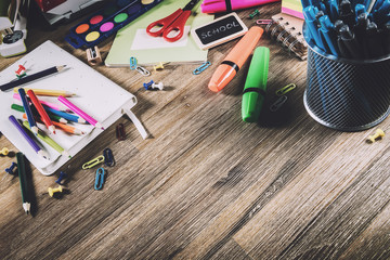 Colorful school supplies over wooden desktop. Back to school