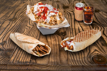 Doner kebab, pita sandwiches and cola on wooden background. For fast food restaurant design or fast food menu