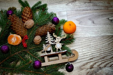 Christmas composition with a branch of spruce, tangerines, pine cones , nuts and toys