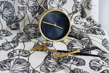 clock with cutlery, on the background of the fabric with a gray pattern, creative background