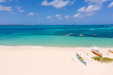 Fototapeta na wymiar White sandy beach with boats. White beach with turquoise lagoon. Seashore in sunny weather.