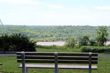 A wood park bench with a view of the river in the valley.