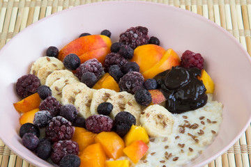 Oatmeal with bananas, apricots, blueberries, blackberries, chocolate paste and sesame seeds