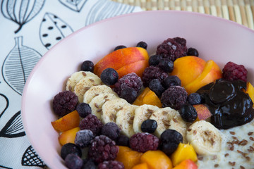 Oatmeal with bananas, apricots, blueberries, blackberries, chocolate paste and sesame seeds