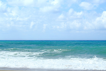 Turquoise sea and blue sky with clouds.