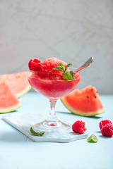 Watermelon slushy with raspberries in weeping glass, summer refreshing drink, frozen fruit dessert