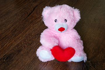 toy teddy with heart isolated on wooden background