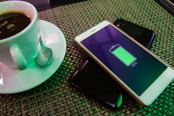 Phone battery wireless charge sharing technology. Wireless charge sharing smartphone in the cafe