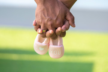 Farther and mother holding Small shoes for the unborn baby