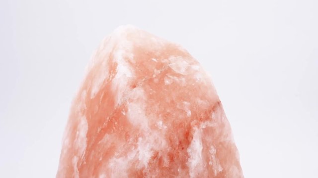 Pink Himalayan crystal salt rotating, (loopable) isolated on white background. Shot in 4K