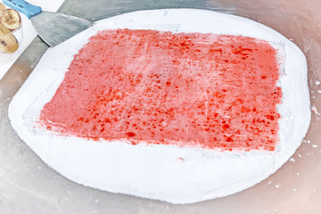 fried rolled ice cream food cooking process top view of icecream sweet roll dessert and strawberry mixture on cooling pan background with white red frozen milk and fruit for handmade ice-cream