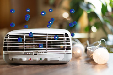 Air ionizator doing air ionization in a living room on a wood table. Health care and comfort concept