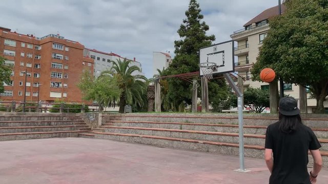 young man playing on the street basketball court 4k slow motion