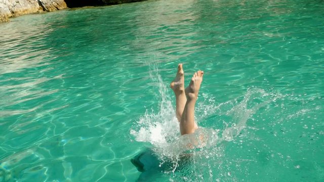 Attractive woman in swimming suit diving into sea with luxury boat on summer vacation in Greece. Slow motion. HD
