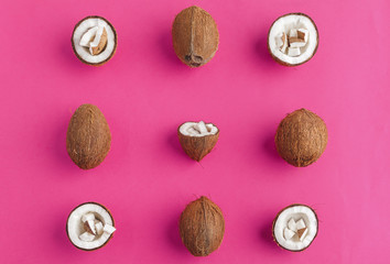 Broken coconut pieces on bright pink background, top view, copy space