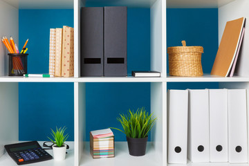 White office shelves with different stationery, close up
