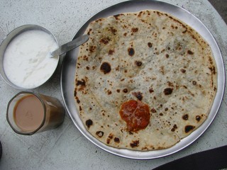 Indian breakfast. Chapati with filling, tea, raita.