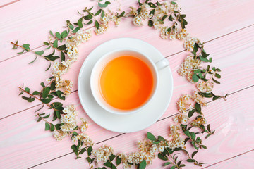 Green tea in a ceramic cup with branches of blossoming tree branches