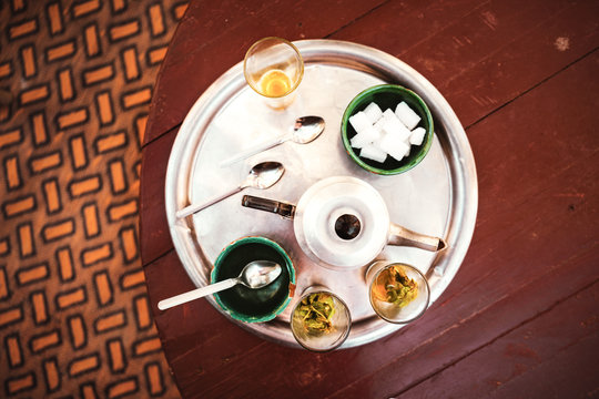 Marokkanischer Minztee in Gl&auml;sern serviert auf einem silbernen Tablett mit einer Teekanne und Schalen vom oben fotografiert