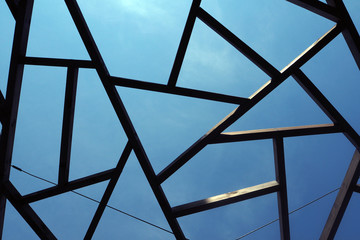 wooden bars in the form of a spider's web against the sky. Pergola decoration.