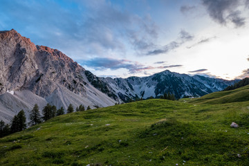 Obraz na płótnie Canvas Idyllische Alm mit mächtigen Bergen im Hintergrund in den österreichischen Alpen