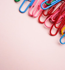 multicolored paper clips on a pink background. The concept is time to school.