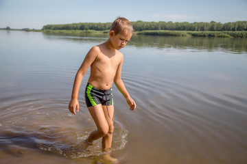 boy in a warm summer is on the water