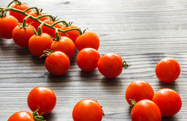 Cherry tomatoes on stem on a black rustic wooden table