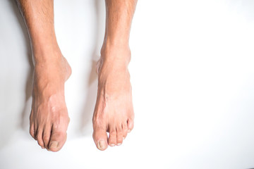 Man's feet hanging on the white background