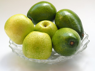 green apples and green avocado in a glass plate. 