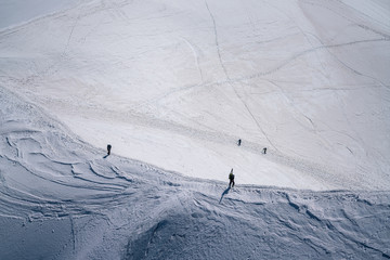Alpinists and skiers ascending on a ridge towards Aiguille Du Midi in Chamonix, France