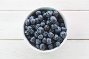Blueberries fruit in bowl on the wooden table background