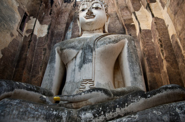 huge 11 m wide and 15 m high seated Buddha in Wat Si Chum  in famous Sukhothai Historical Park, a UNESCO World Heritage Site, the ancient 13th and 14th centuries capital of Sukhothai. Thailand