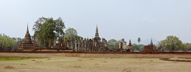 Obraz premium Beautiful panorama of Ruins in famous Sukhothai Historical Park, a UNESCO World Heritage Site, Foggy spring day in the ancient 13th and 14th centuries capital of Sukhothai. Thailand