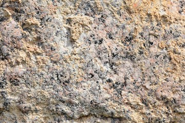 Natural stone background with textured surface. Pattern rocks with rough structure. Aging colorful mountain backdrop. Natural stone surface with empty space for image or text. Aging granite texture