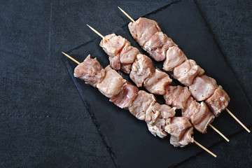 Raw marinated shashlik on wooden sticks. Meat dish. Pork shish kebab.