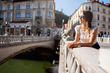 Fototapeta na wymiar Young smiling woman standing by the Bridge