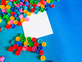 Top children's toys on the floor on white paper. Developing colorful toys. Frame of children's toys on a blue background with white paper