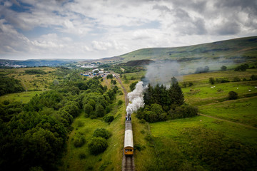 Aerial view of Landscape with steam train of the heritage railway in Blaenavon driving along Garn...
