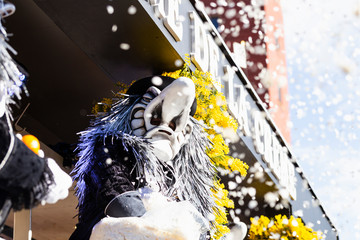 Marktplatz, Basel, Switzerland - March 13th, 2019. Close-up of a waggis throwing confetti from his carnival float