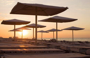 Silhouettes of beach umbrellas in the background of  sunrise