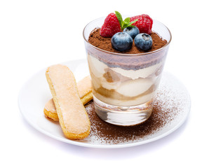 Frame made of Classic tiramisu dessert with blueberries and raspberries in a glass and savoiardi cookies isolated on a white with clipping path