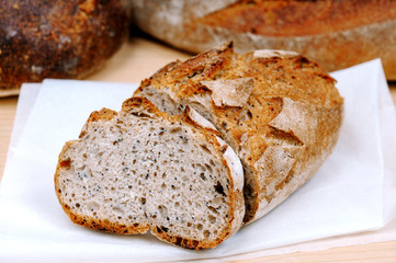 Freshly baked hommade organic bread in rustic setting. Bakery. Close-up on traditional bread.