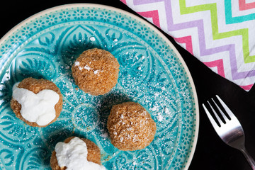 Cottage cheese dumplings with breadcrumbs and powdered sugar on a rustic plate