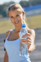 fitness athlete woman drinking water after work out exercising on sunset evening summer in outdoor...