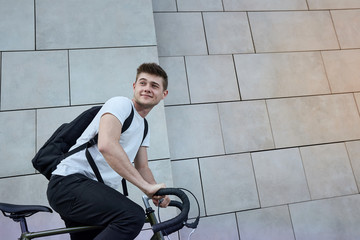 Handsome hipster man posing with bicycle in the city.