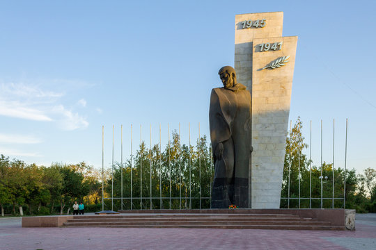 Sightseeing Kazakhstan. Panorama view on lonely Monument of the unknown soldier (second world war). The Person is standing in uniform. Location: Downtown, Temirtau, Karaganda Region, Kazakhstan. Asia