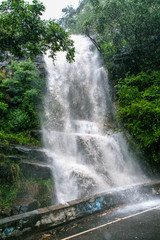 disaster. waterfall after rain pours water onto mountain road. Flooding after heavy rain. Splash spontaneous waterfall flooded road.