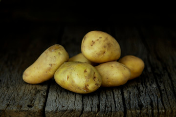 Fresh potatoes on an old wooden table