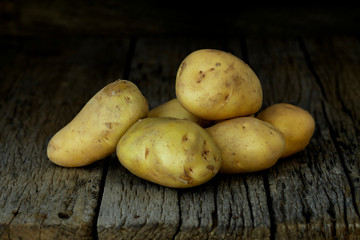 Fresh potatoes on an old wooden table